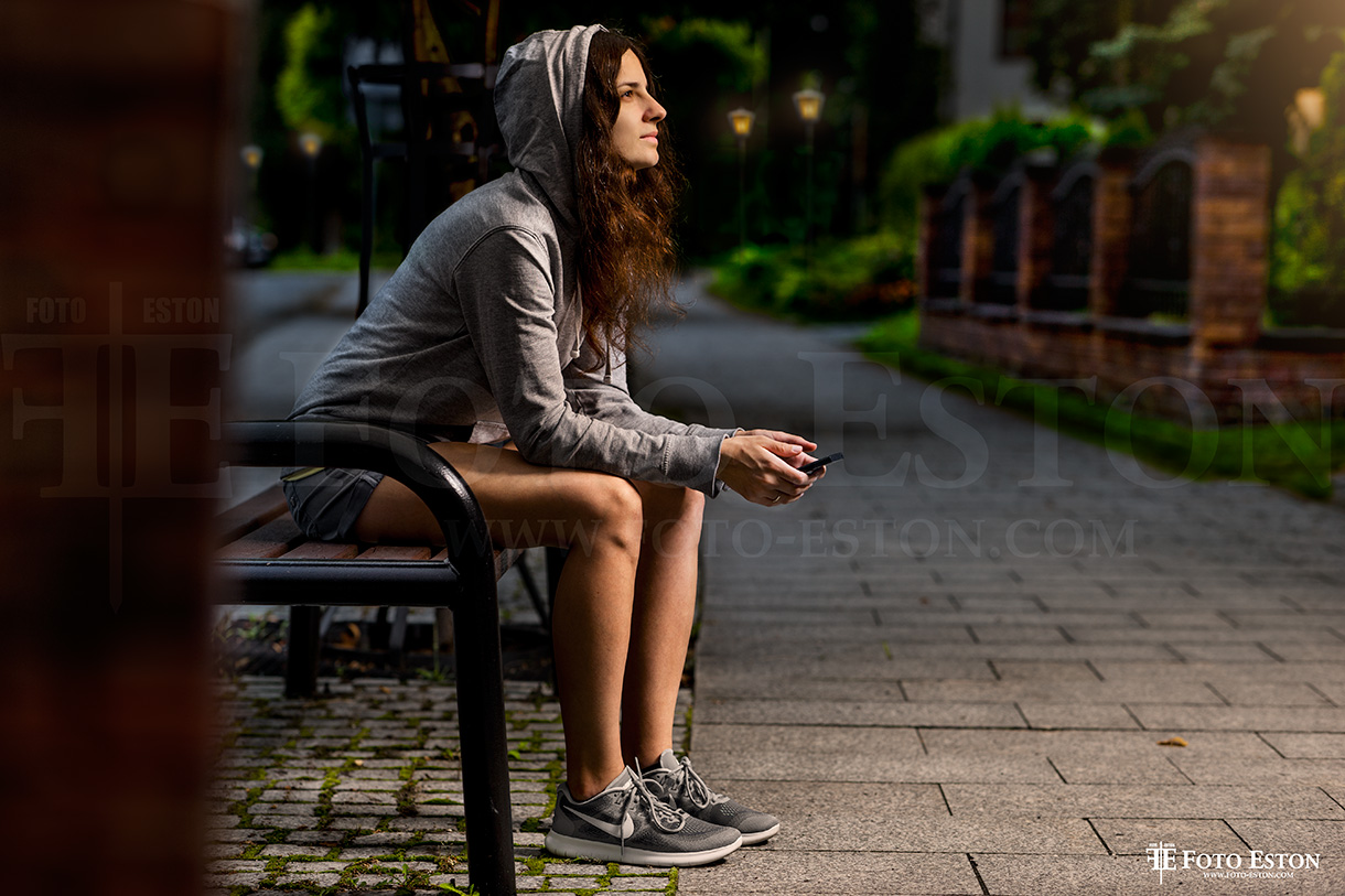 Dziewczyna siedzÄ…ca na Ĺ‚awce przy ulicy. Fotografia portretowa na potrzeby artykuĹ‚ow i innych wyraĹĽeĹ„ medialnych